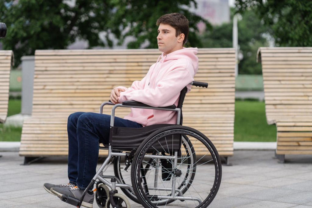 Hombre joven usuario de silla de ruedas en un espacio público al aire libre.